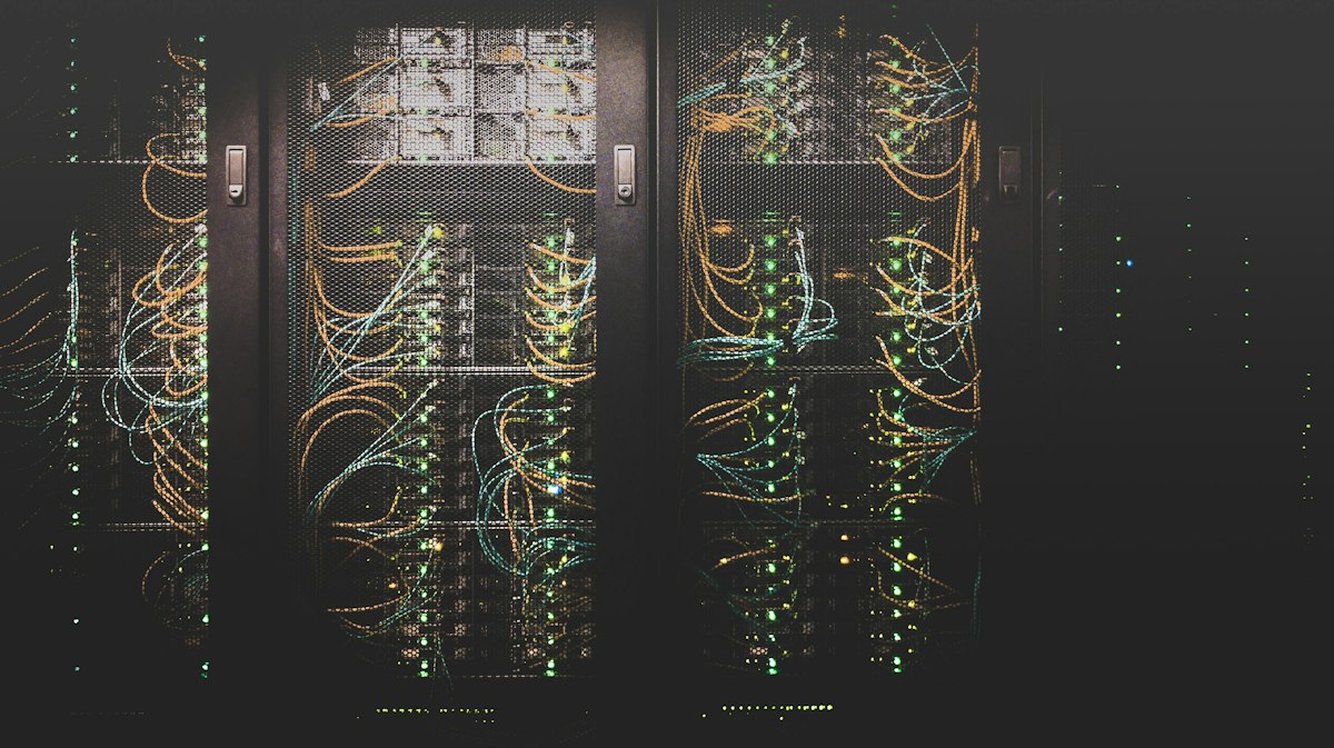 Blue-lit server racks with dense network cabling, illustrating why network segmentation limited the blast radius of the DIVD breach