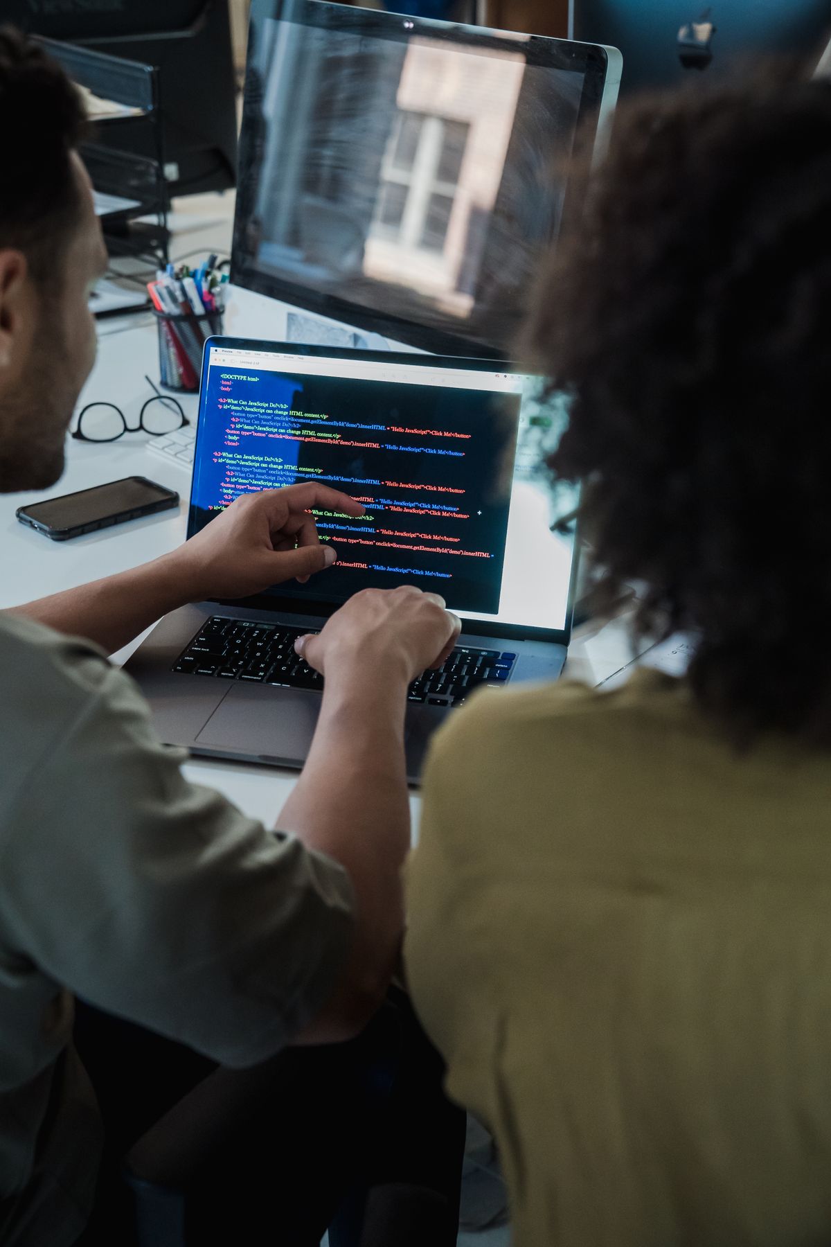 Two developers pair-programming over code