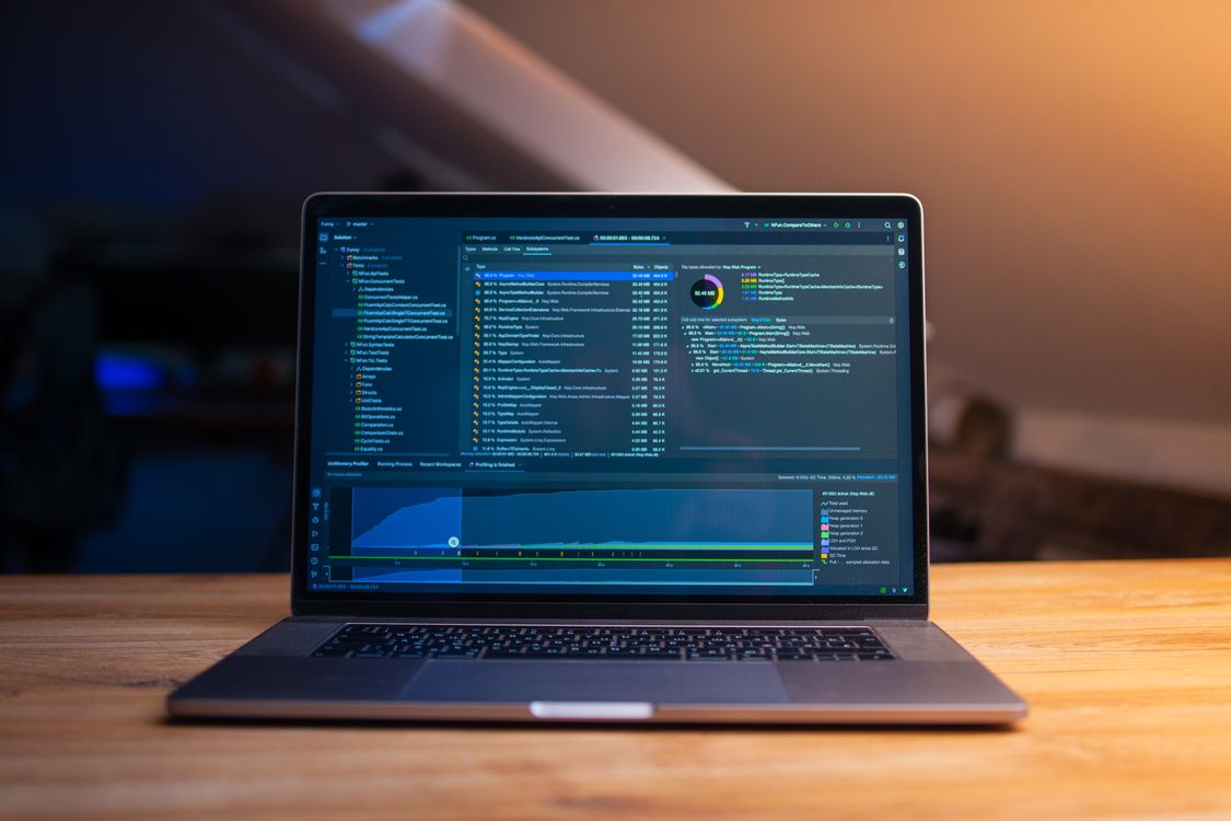 Modern laptop on a wooden desk with code displayed on the screen, representing the reusable Skills and development work behind agent capabilities
