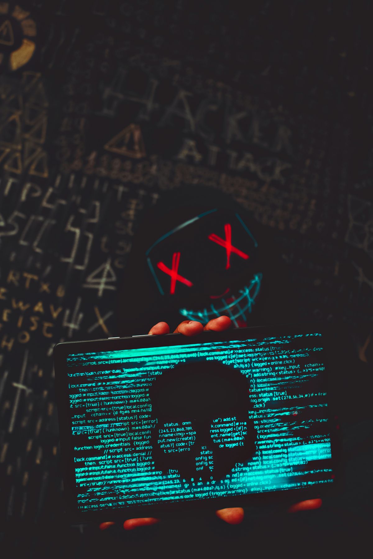 Masked figure with a laptop showing code — the human side of a sandbox escape