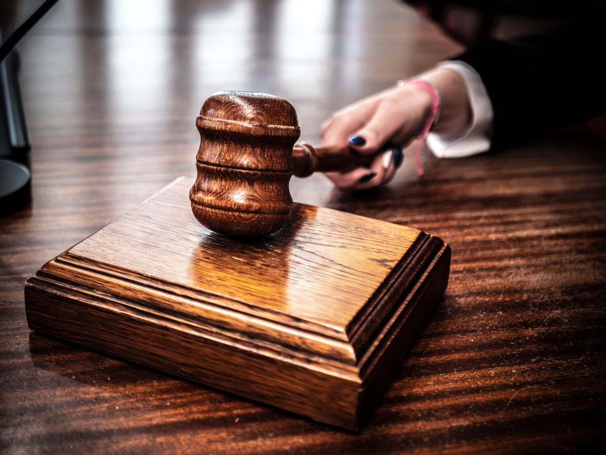 Wooden gavel on a judge's bench in a courtroom, representing the legal scrutiny of AI agent containment