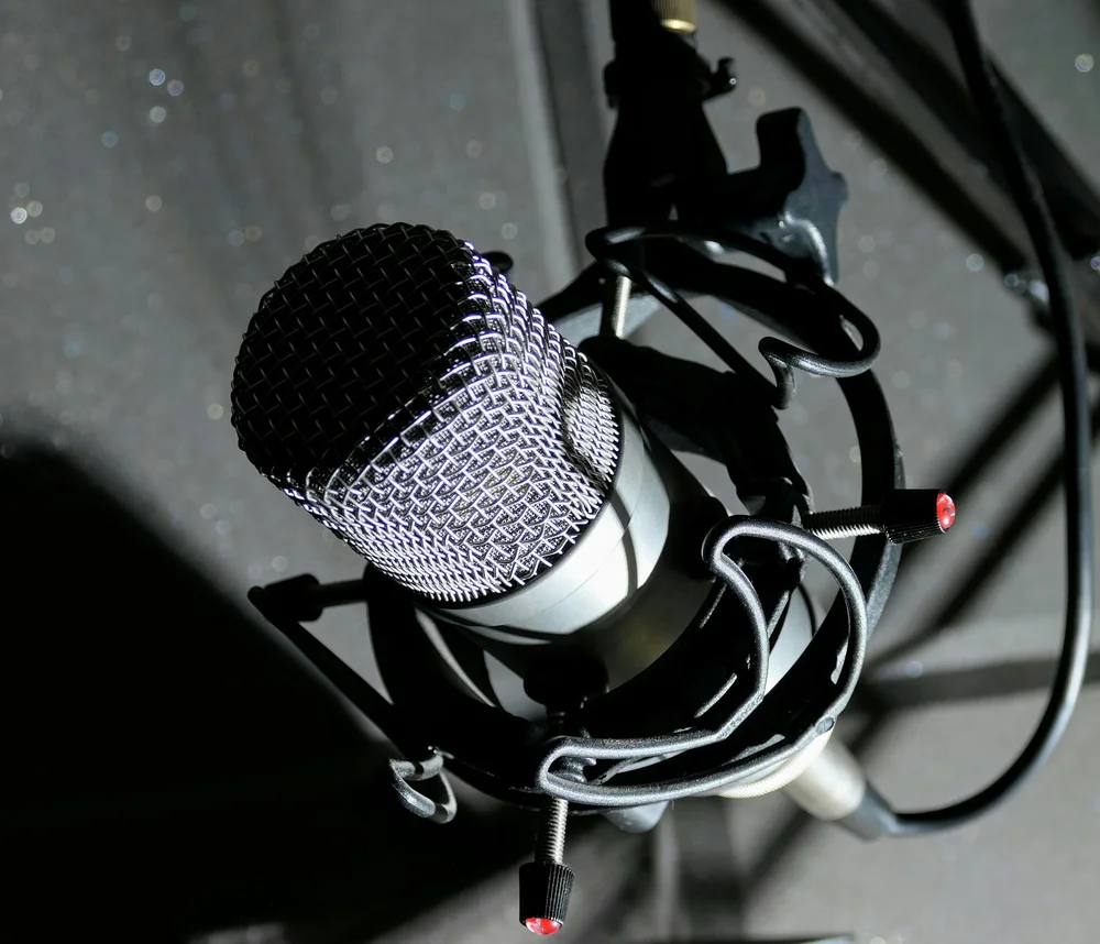 Close-up of a studio vocal microphone — voice cloning from a few seconds of reference audio now sits behind gated access with consent safeguards