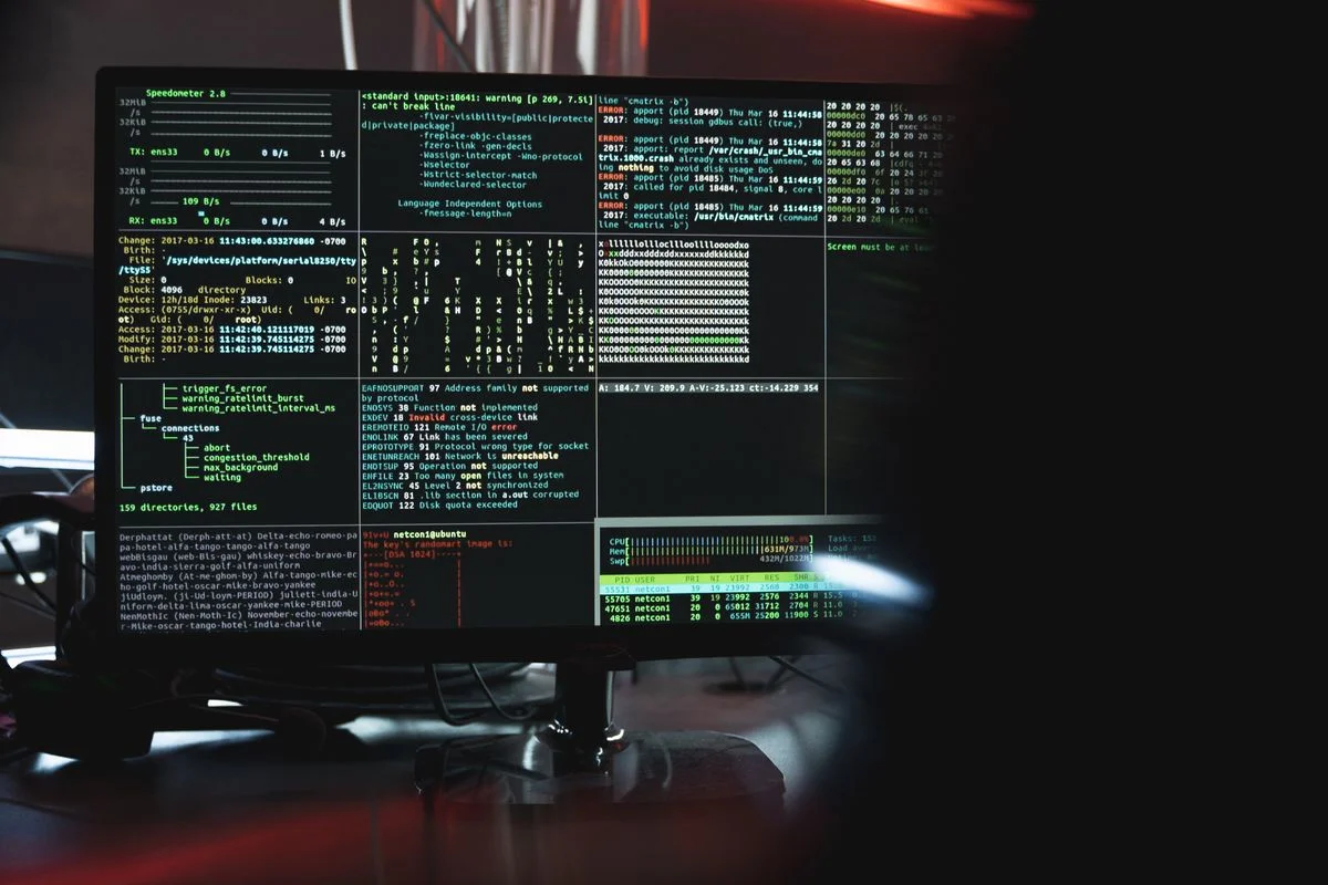 Terminal windows showing system diagnostics and log output on a monitor in a dark room