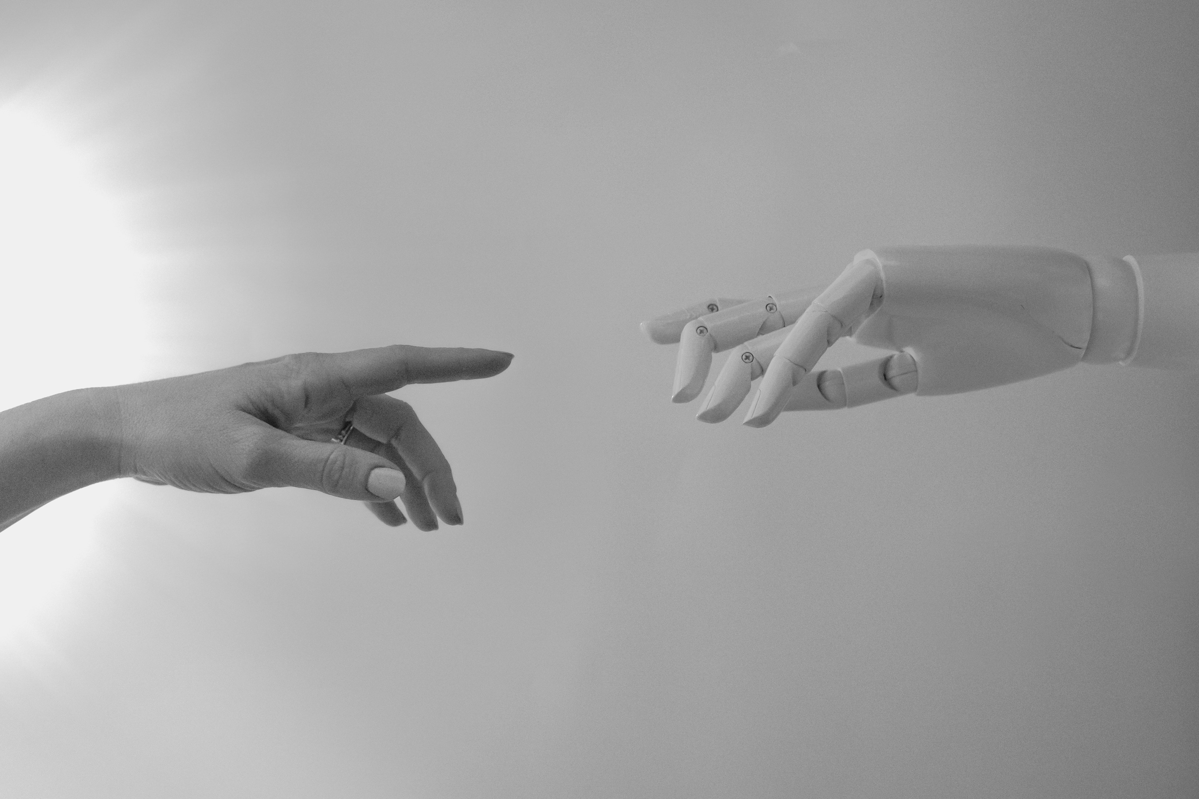 A human hand reaching toward a robotic hand, mirroring Michelangelo's Creation of Adam — a symbol of human oversight over AI agents