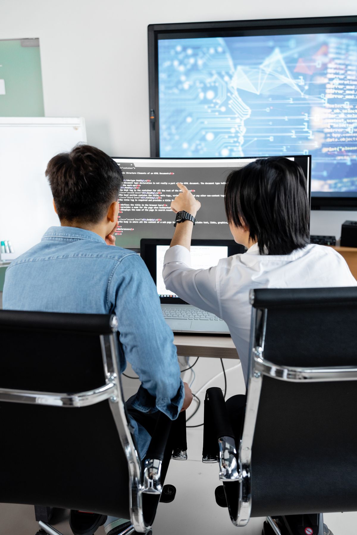 Developer working with multiple monitors — coordinating a 100-agent swarm multiplies oversight work, not removes it