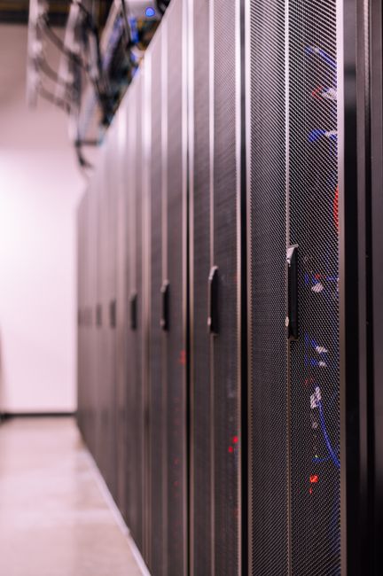 Server racks in a data center — Turso's trick is that one server can hold millions of mostly-idle databases, waking each only when an agent needs it