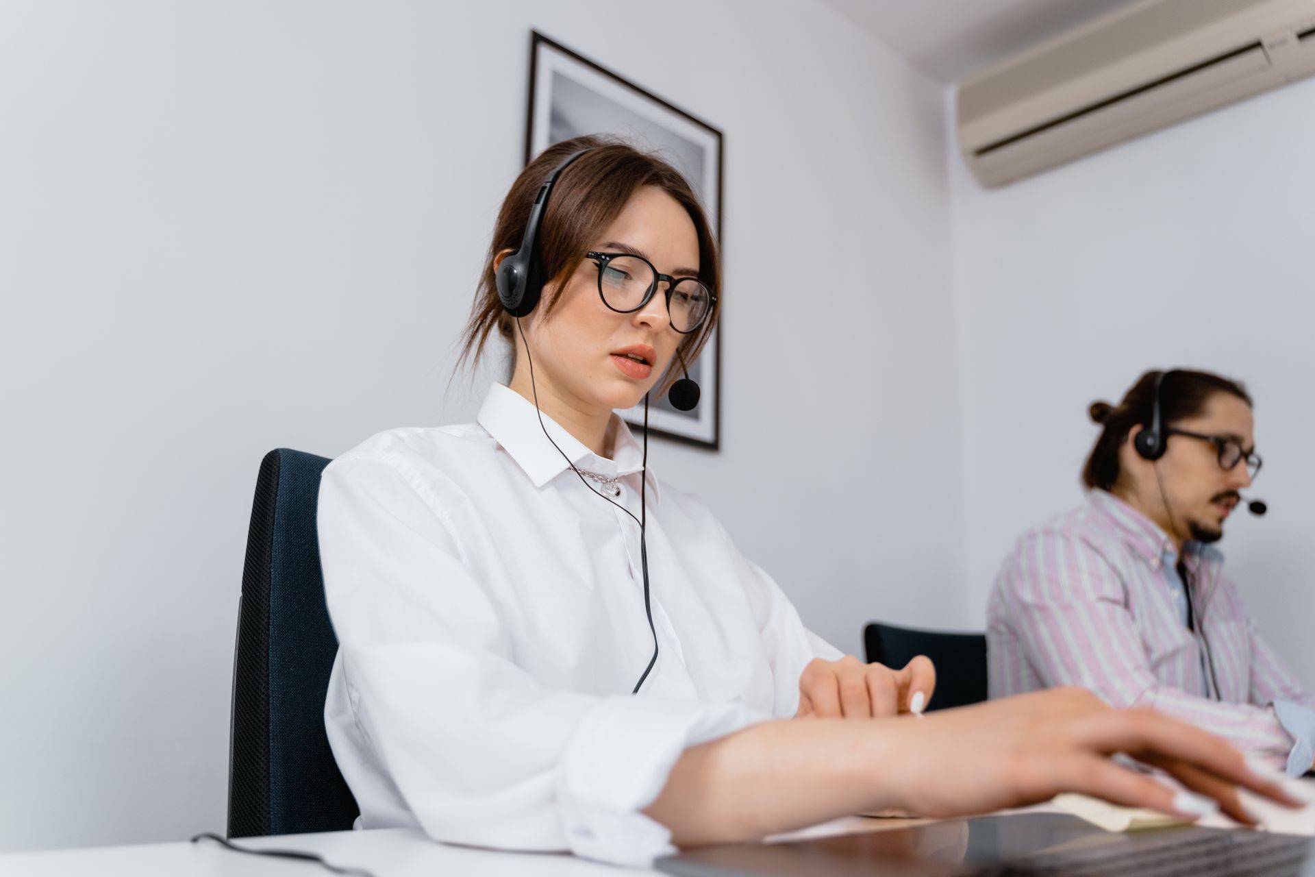 Customer support agent at a desk with a headset, the kind of repetitive question-answering a RAG chatbot takes over