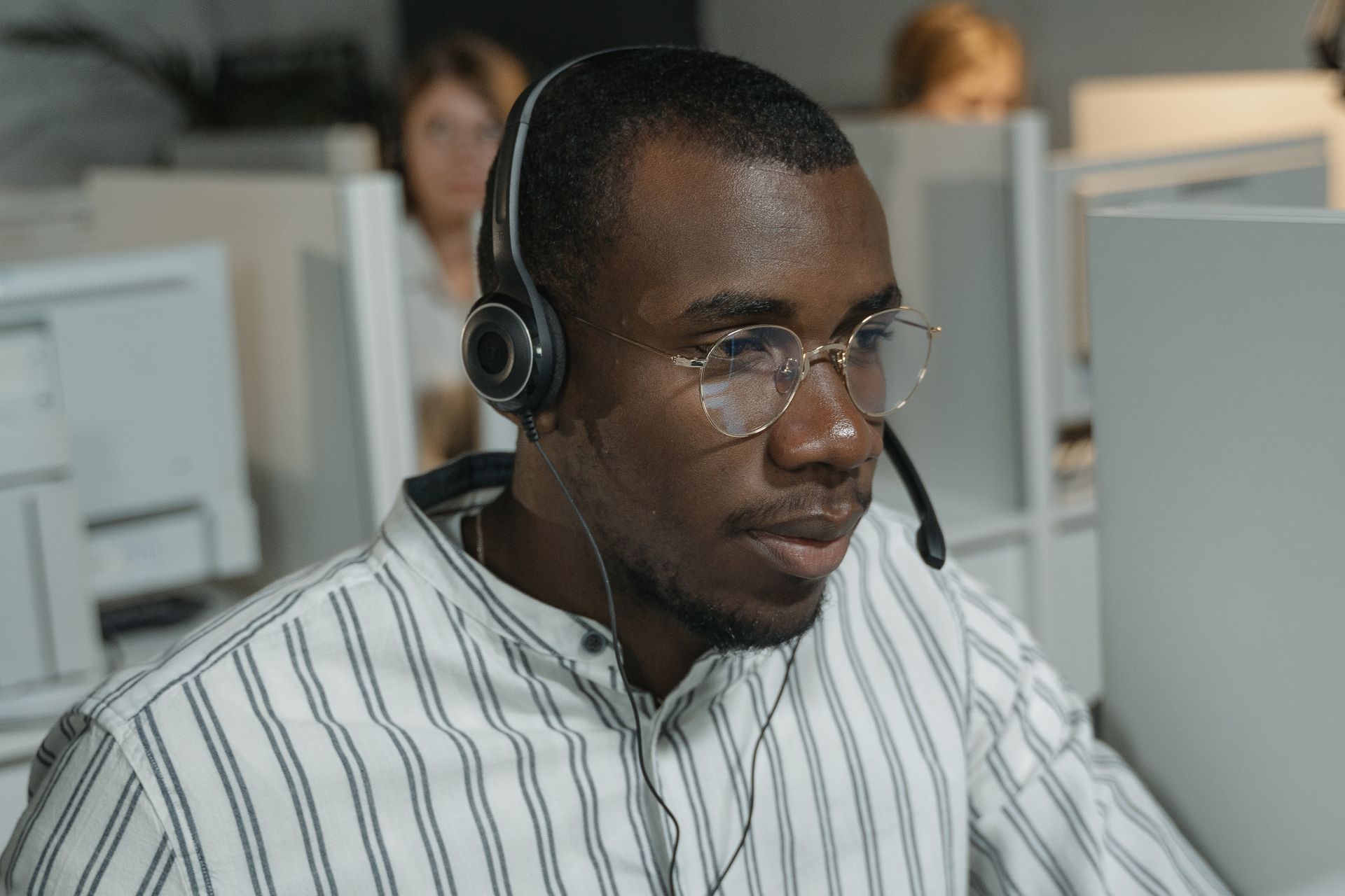 Call center agent wearing a headset, focused on a customer conversation