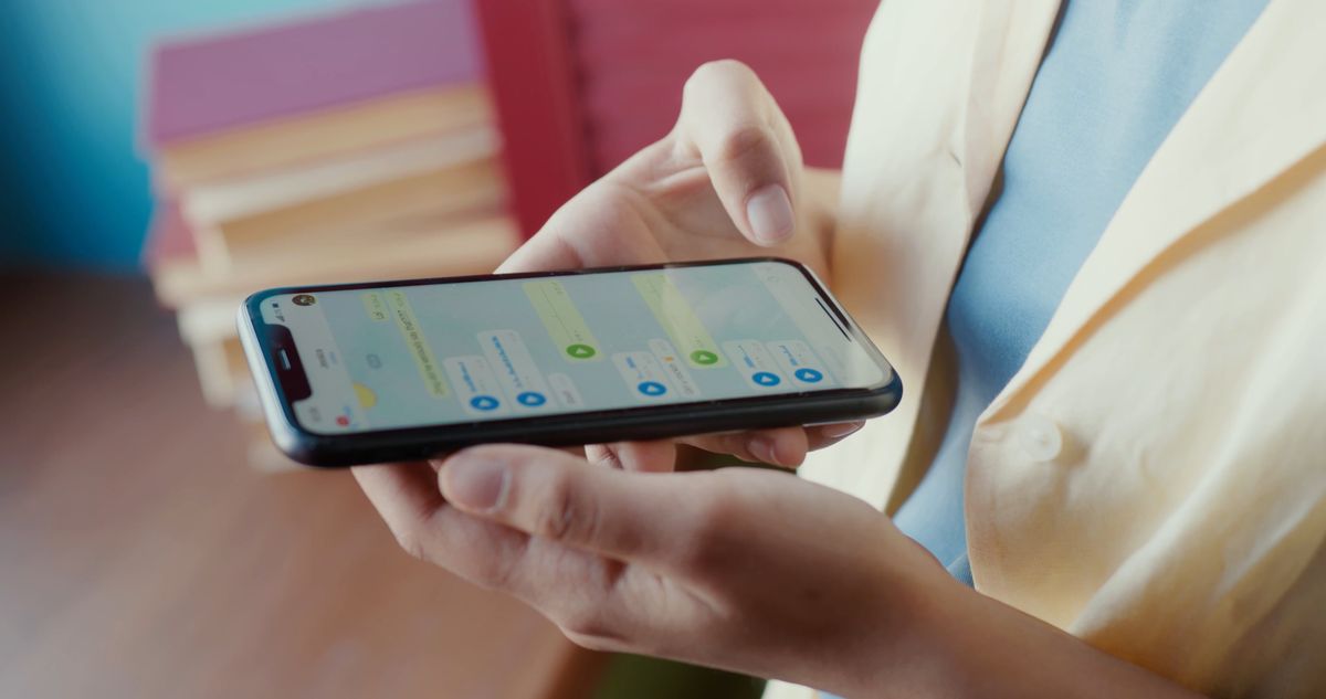 A person holding a smartphone with a customer support chat conversation open