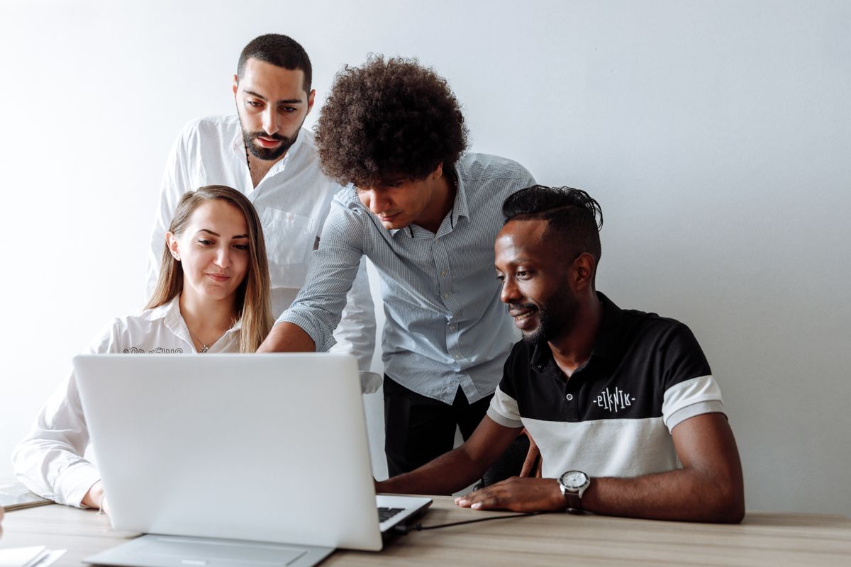 A diverse team collaborating around a laptop — enrichment moves into the workflow where the team already works